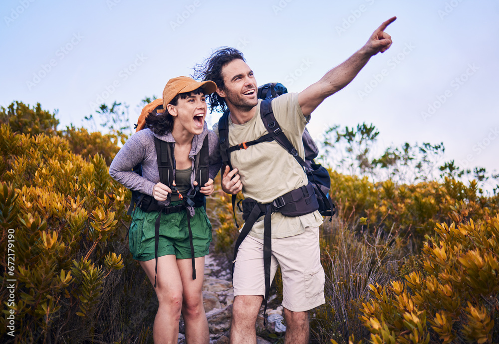 Hiking, pointing and excited couple in nature for adventure, holiday and journey on mountain. Travel, dating and man and woman walking with surprise and wow for view, trekking and backpacking outdoor