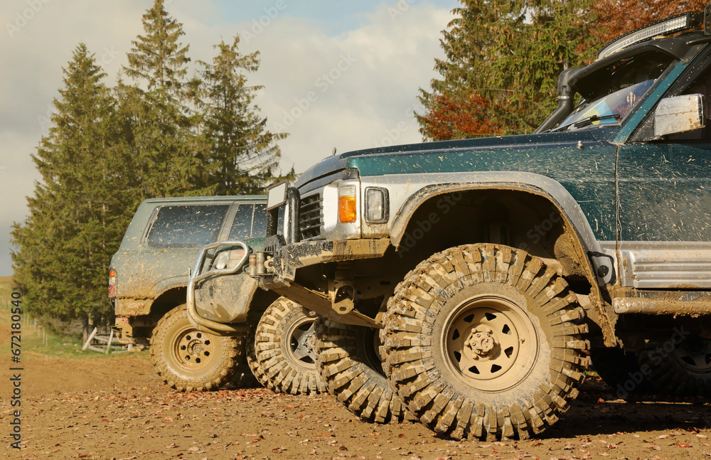 Automobile in a countryside landscape with a mud road. Off-road 4x4 suv automobile with ditry body after drive in muddy road area Automobile in a countryside landscape with a mud road. Off-road 4x4 suv automobile with ditry body after drive in muddy road area
