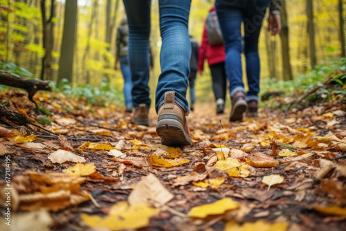 Close up of group tourists walks along the path in the autumn forest. Travel concept of vacation and holiday.