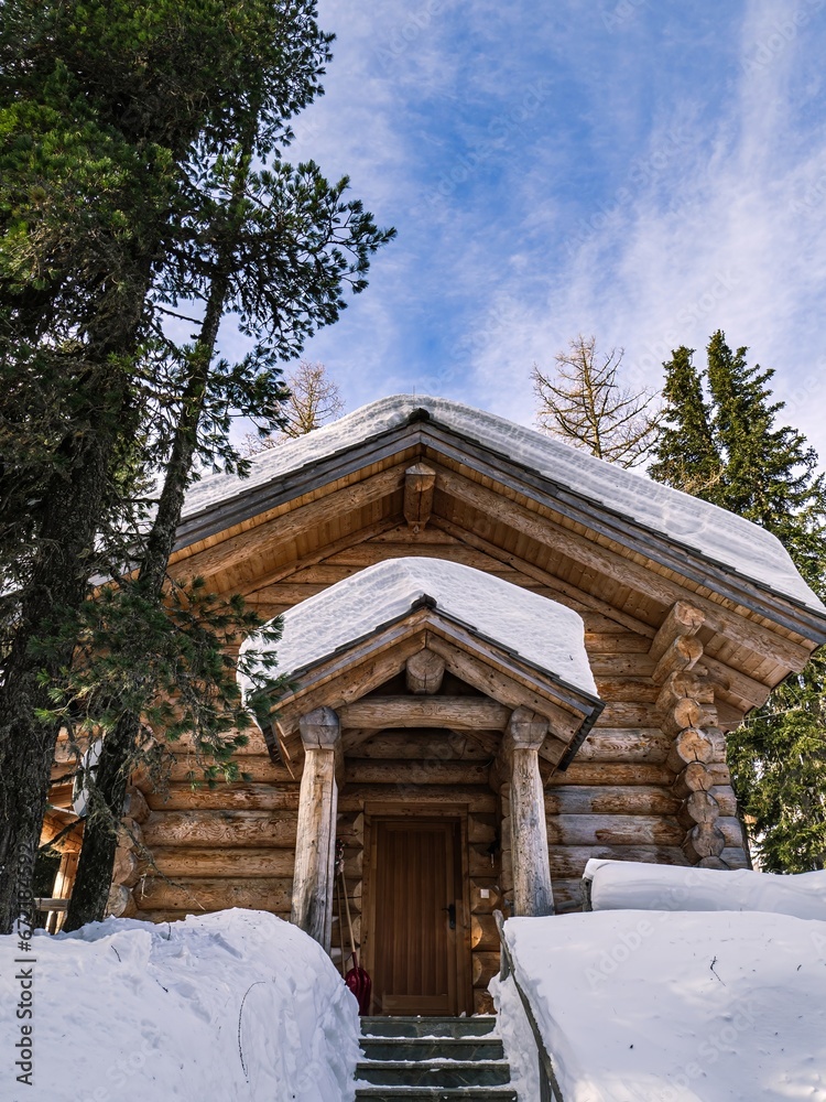 Frontal view of a traditional alps village log house during winter snow Frontal view of a traditional alps village log house during winter snow