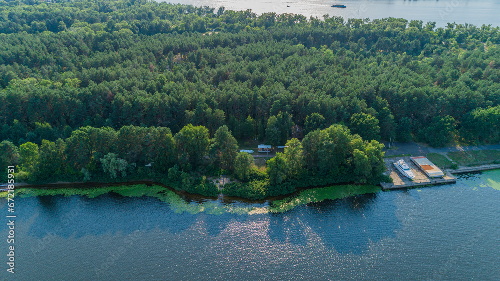Fototapeta premium Aerial view summer forest and river in sunny day. Drone shot beautiful nature landscape, green trees