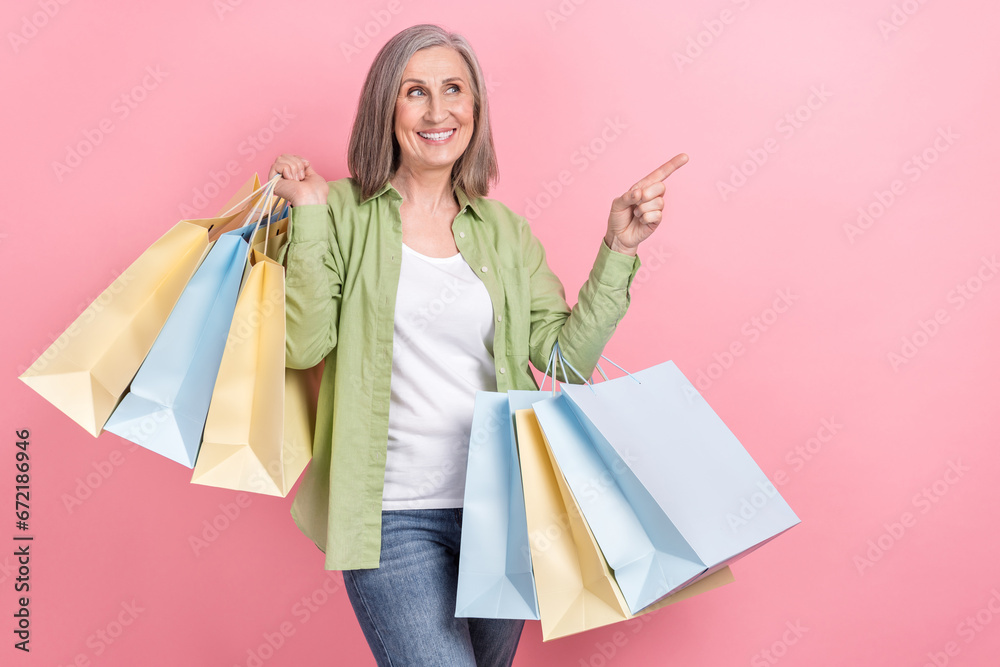 Photo of cheerful lovely pensioner wear green trendy outfit recommend nice collection empty space isolated on pink color background