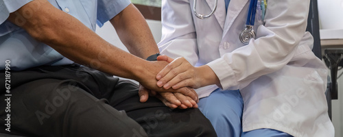 close up, an elderly male patient holds hands with a nurse who comes to take care of and help encourage each other.