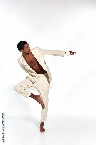 handsome african american man in elegant suit posing in motion and looking away, fashion concept
