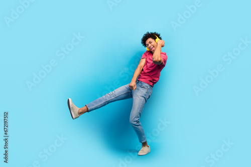 Full body photo of handsome young male dancer yellow have fun earphones wear trendy pink outfit isolated on blue color background