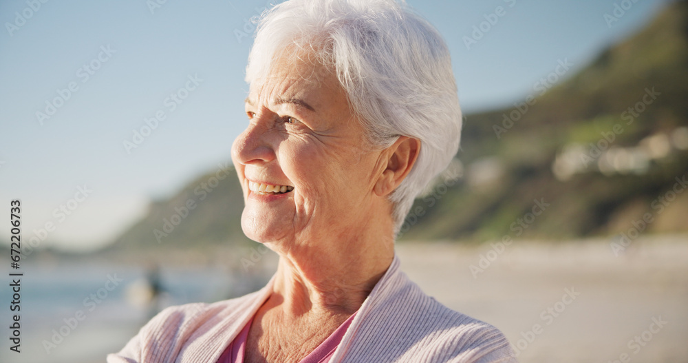 Fototapeta premium Senior woman, smile and sunset on beach to relax with peace outdoor in nature, sea and elderly female person with mindfulness. Happy, face and old lady thinking by a ocean on holiday in retirement