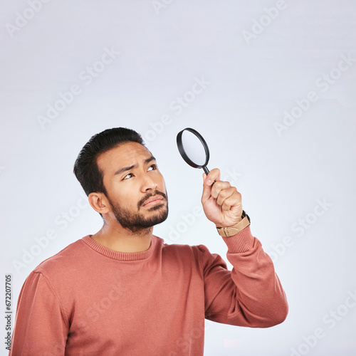 Magnifying glass, man and serious in a studio with investigation for clues. Isolated, white background and male person with inspection for scam, crime evidence and information search with mockup