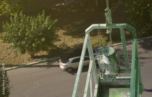 Hoist supply and safety lock as part of suspended wire rope platform for facade works on high multistorey buildings. Hoist for elevation, raising or lifting cradle platform photo