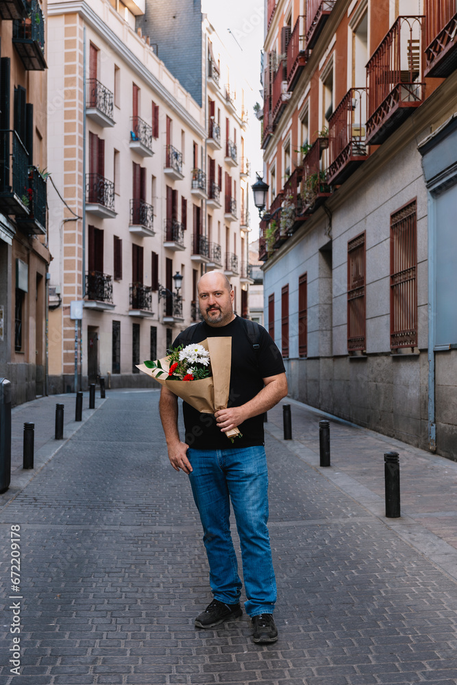 Casual looking man in his 50s, in love, holding a bouquet of flowers on a city street Casual looking man in his 50s, in love, holding a bouquet of flowers on a city street