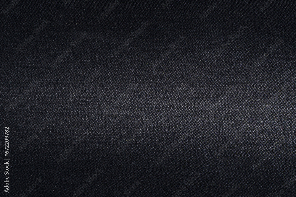 Close-up of the texture of black denim fabric with fraying. Material for making jeans. Background for your design Close-up of the texture of black denim fabric with fraying. Material for making jeans. Background for your design
