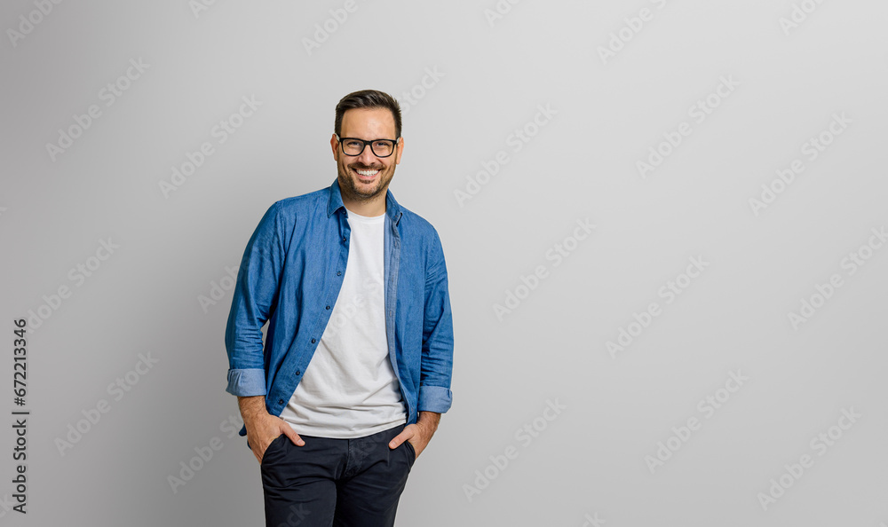 Confident young businessman with hands in pockets smiling and standing isolated on white background Confident young businessman with hands in pockets smiling and standing isolated on white background