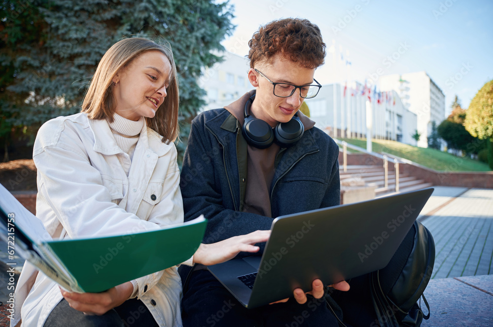 Two young students are together outdoors Two young students are together outdoors