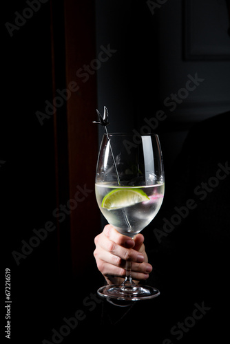 side view of transparent cocktail with ice on a dark background