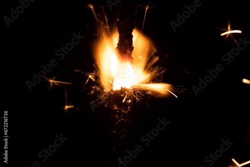 Burning sparkler on a black background. Sparks from a burning fire.