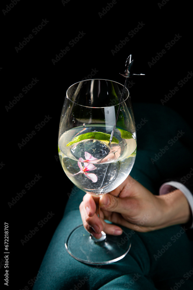 side view of transparent cocktail with ice on a dark background