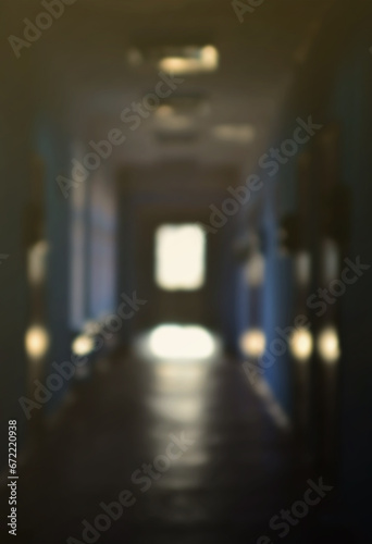 The blurred image of gloomy corridor of a neglected public building. Defocused picture of a public space in a poor residential high-rise building