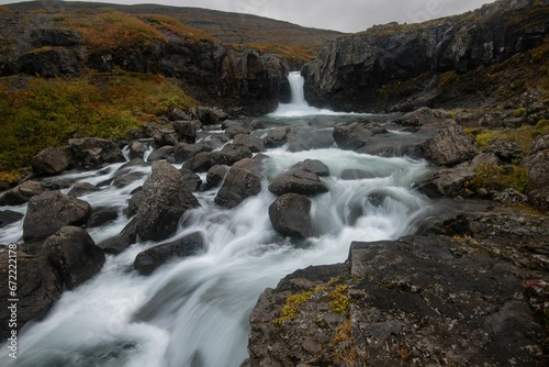 Waterfall cascading over a backdrop of rocky terrain.