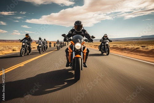 A group of motorcyclists ride motorcycles together on an empty road. photo