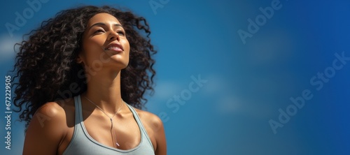 Young black woman looking at sunny blue sky
