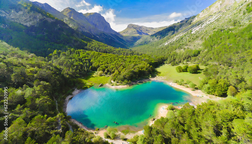 Drone view of lake surrounded by lush green forest in the sunlight next to mountains