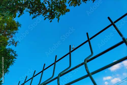 Metal fence blocks access to the blurred plane flying away from us. Concept of abstract boundaries imposed on us by the system, restrictions on the rights to freedom, movement, and free thought photo