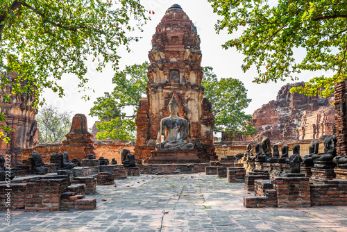The large ancient Buddha statue in Wat Mahathat at Ayutthaya Historical Park is a popular tourist attraction. photo