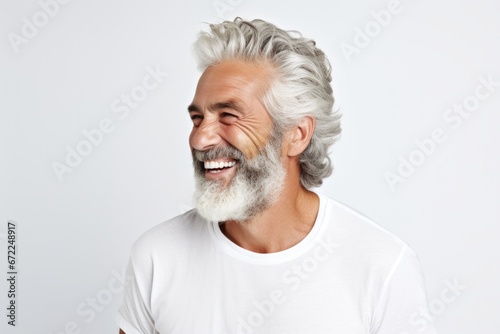 Portrait of a handsome mature man smiling , looking aside over white background, copy space  photo