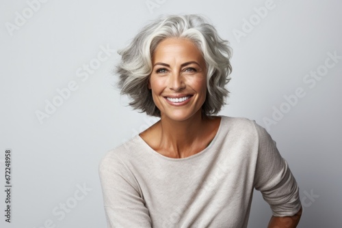 Attractive Mature woman looking strong and confident smiling and relaxing and looking at the camera.  © Inga