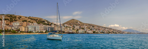 Panorama of Sarande´s waterfront with a sailing boat in the foreground
