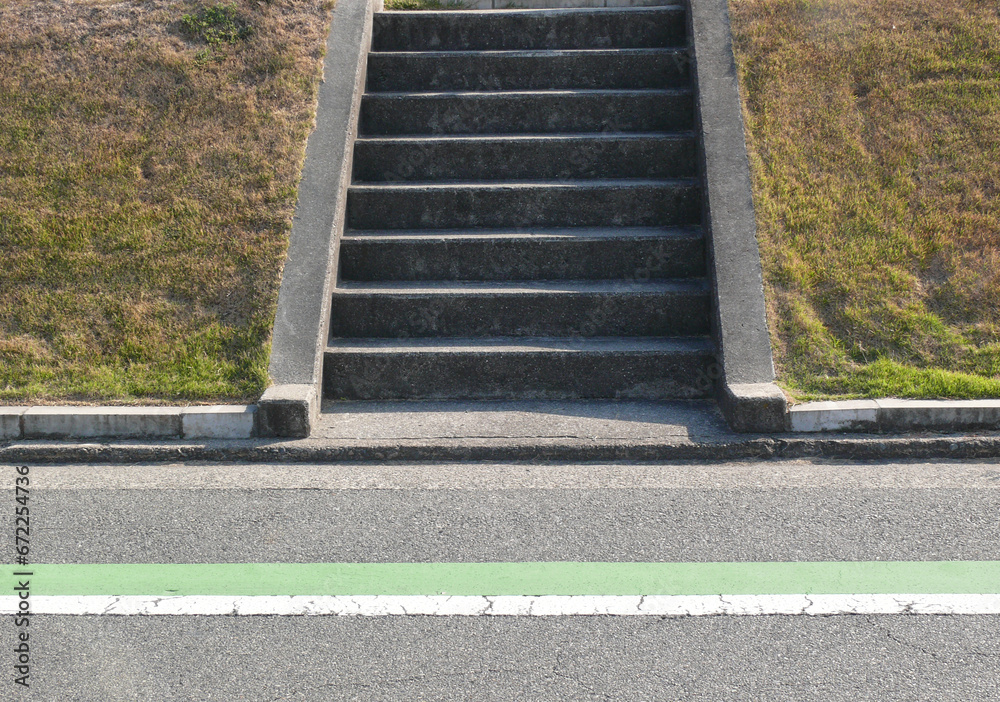 Obraz premium 道路脇の土手を登る階段。