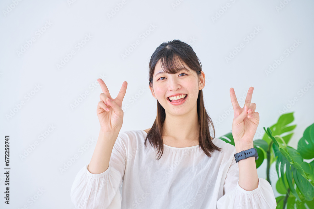 ピースサインをする若い女性 ピースサインをする若い女性