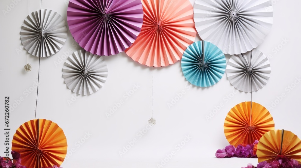 Colored paper decorations in the form of a round fan for a children's holiday party or wedding photo shoot on a white isolated background