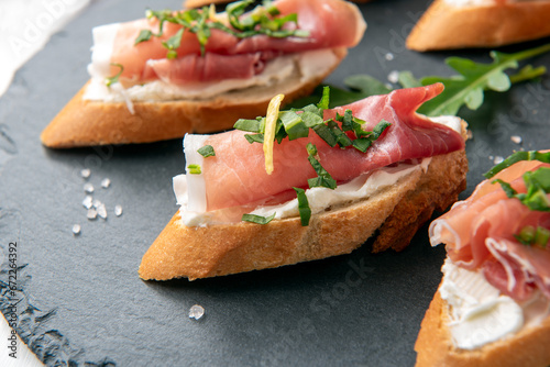 Deliziosi crostini con prosciutto crudo e crema di formaggio, antipasto italiano, cibo europeo 