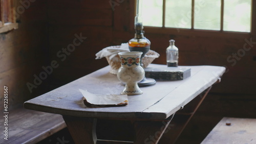 Traditional rustic ambience, rural furniture on display at farmhouse. Objects on display at wooden table by window