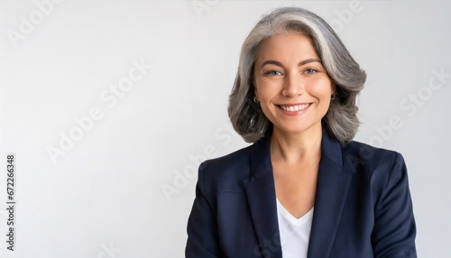 Smiling beautiful mature business woman standing isolated on white background. Older senior businesswoman, 60s grey haired lady professional coach looking at camera, close up face headshot portrait