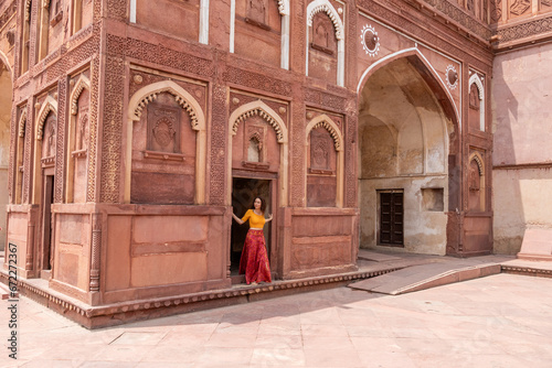 Woman walks through the great Agra Fort in Agra, India, with its wonderful architecture on a cloudy day photo