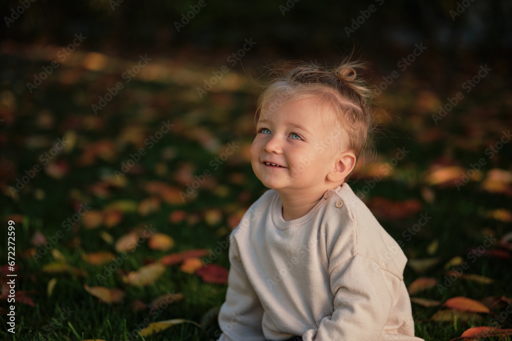 A smiling toddler child isolated on the nature background. A smiling toddler child isolated on the nature background.