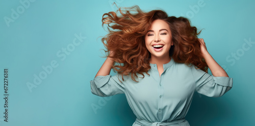 Beautiful happy woman model posing touches hair on blue background