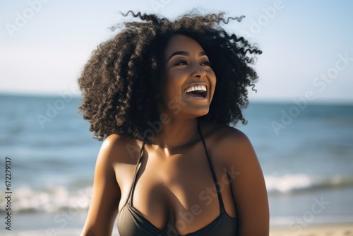 Young chubby black woman having fun at beach. Cheerful friends enjoying at sea. photo