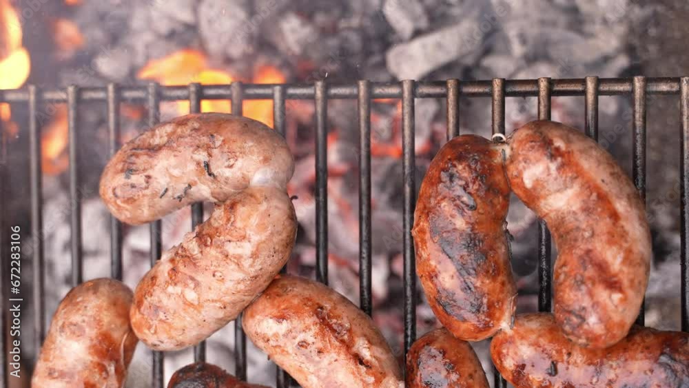 Flatlay overhead shot of cooking sizzling sausages BBQ using a fork on a grill. Barbecue.