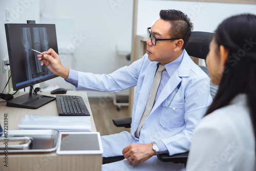 Doctor checks patient's joint bones on computer screen at clinic