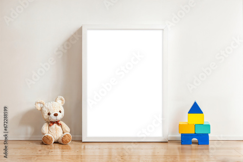 white wood frame canvas mockup template in kids nursery room with teddy bear and wooden block toys A4 transparent placeholder space