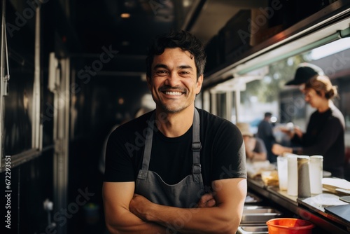 Smiling mid adult male owner looking away while standing in food truck