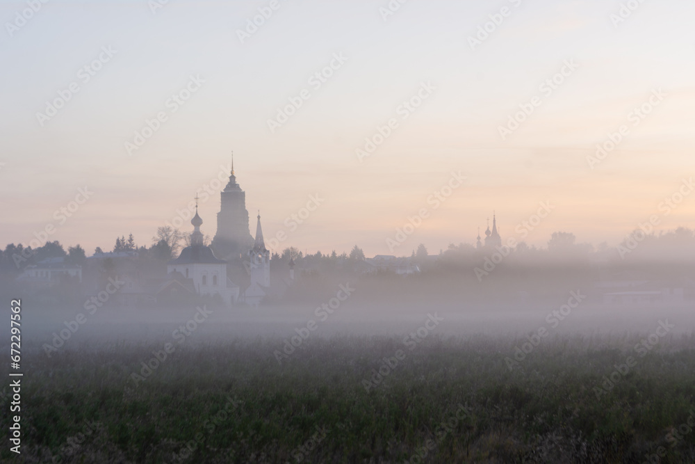 autumn landscape with soft morning light, church at dawn in the fog. Suzdal, Russia - obrazy, fototapety, plakaty 