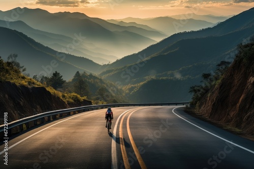 A captivating image of a solo cyclist racing along a winding mountain road, with the backdrop of breathtaking natural scenery, capturing the exhilaration and freedom of outdoor sports. photo