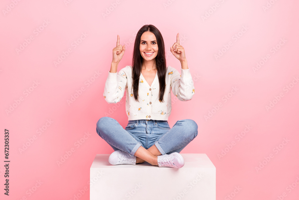 Full length photo of cute sweet lady wear white cardigan pointing two finger up empty space isolated pink color background Full length photo of cute sweet lady wear white cardigan pointing two finger up empty space isolated pink color background