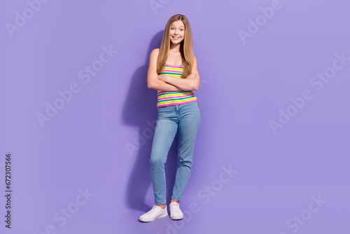 Full length photo of lovely teen blonde lady folded hands confident dressed stylish striped garment isolated on violet color background