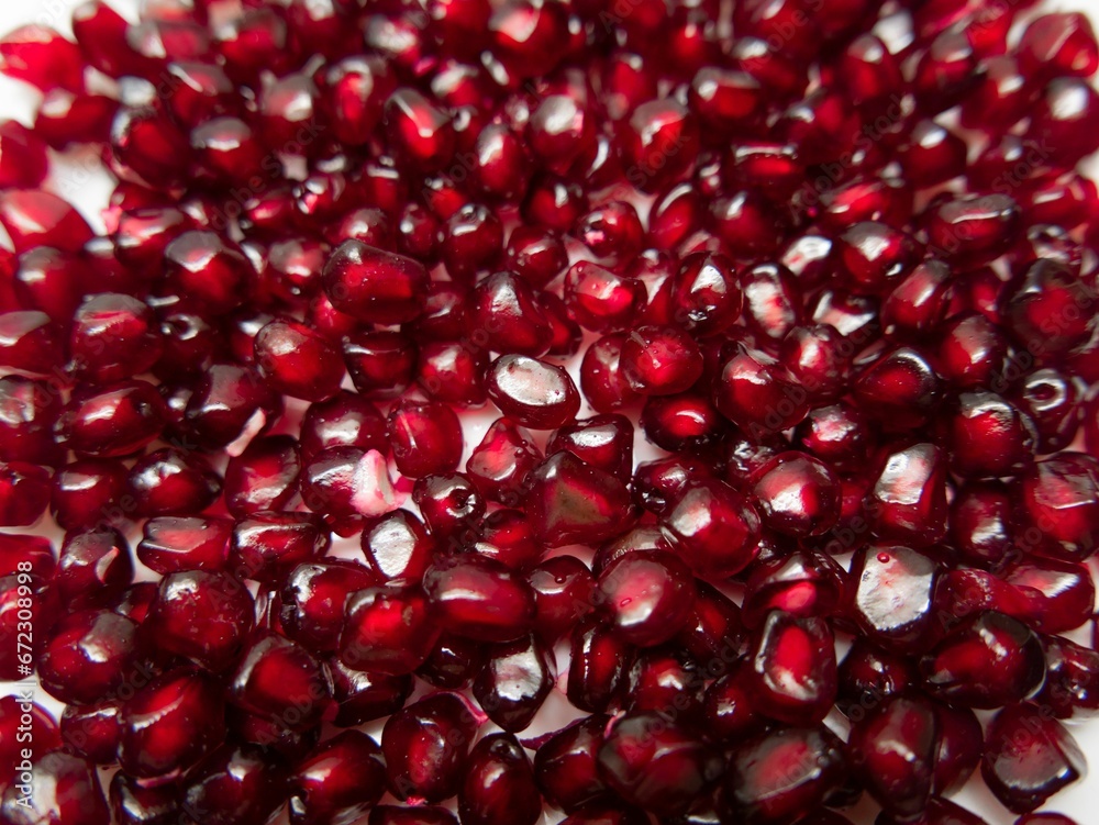Close-up of a plate with a fresh pomegranates isolated on a white background Close-up of a plate with a fresh pomegranates isolated on a white background