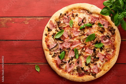 Pizza. Traditional Bacon pizza with ham, mushrooms, pickled cucumber and cheese and cooking ingredients tomatoes basil on wooden table backgrounds. Italian Traditional food. Top view. Mock up.