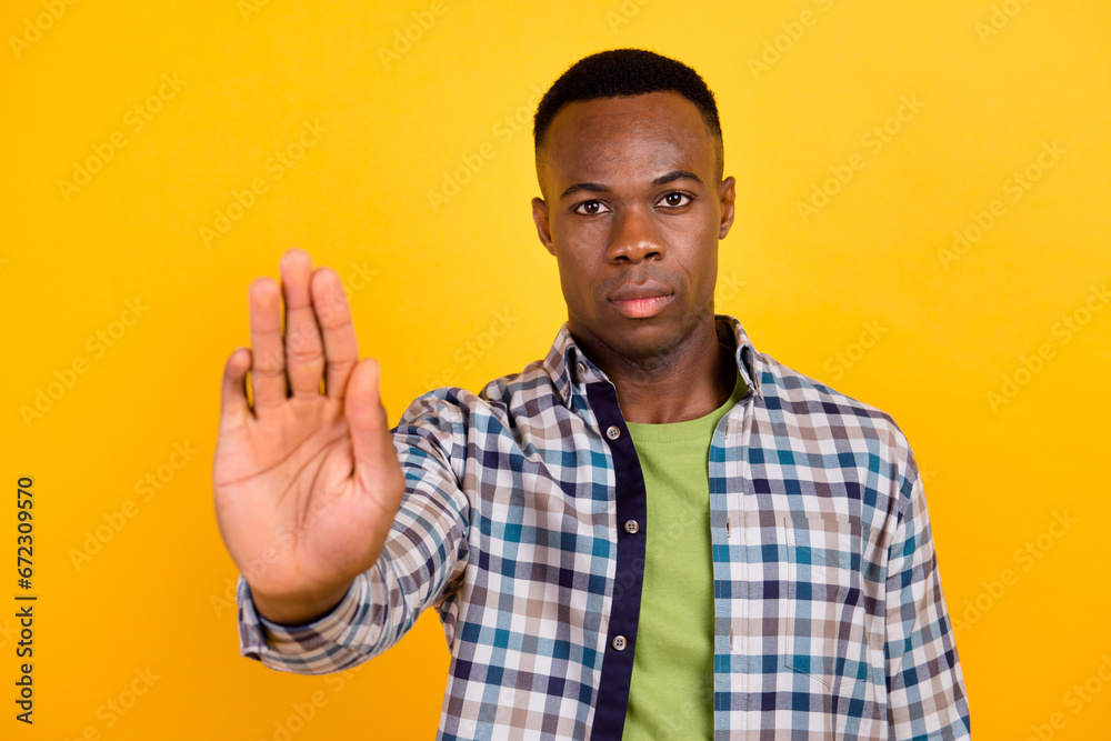 Fototapeta premium Photo of young concentrated worker guy wear plaid shirt demonstrate stop enough discrimination isolated on yellow color background